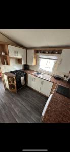 cocina pequeña con fogones y ventana en 8 berth Waterside Ingoldmells V8 Santanavan 3, en Skegness