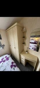 a bedroom with a bed and a dresser and a mirror at 8 berth Waterside Ingoldmells V8 Santanavan 3 in Skegness