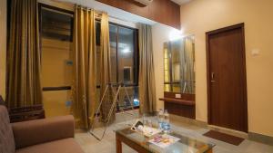 迪卡Hotel New Sagar Priya !! Beachfront with Swimming Pool !!的带沙发、桌子和窗户的客厅