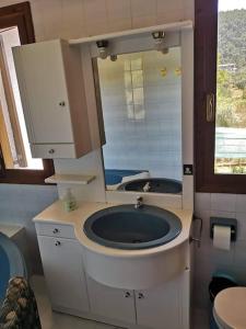 a bathroom with a sink and a mirror at Villa next to the beach in Vourvourou