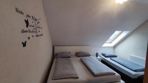 a room with two beds in a attic with a window at Ferienwohnung Familie Schreiter in Neudorf