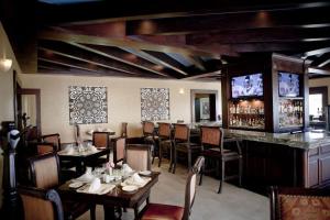 a restaurant with tables and chairs and a bar at Four Fabulous 3BR Villa Unique View in Cabo in Cabo San Lucas