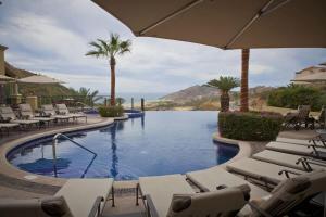 a swimming pool with lounge chairs and an umbrella at Four Fabulous 3BR Villa Unique View in Cabo in Cabo San Lucas