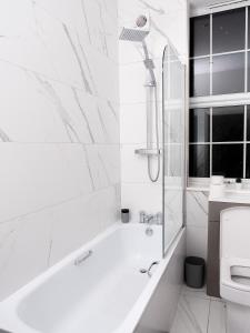 Baño blanco con bañera y lavamanos en Apartment in Brighton en Brighton & Hove
