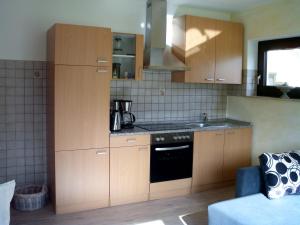 a kitchen with wooden cabinets and a stove top oven at Ferienwohnung Familie Balko in Arnsberg