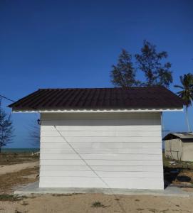 eine weiße Garage mit schwarzem Dach in der Unterkunft Chalet Bonjour in Bachok