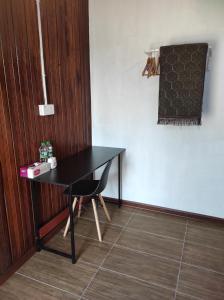 a black table and a chair in a room at Chalet Bonjour in Bachok