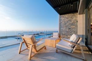 a patio with two chairs and a table and a pool at Fuga Panorama in Bodrum City