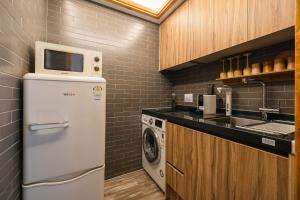 a small kitchen with a refrigerator and a microwave at Luxury hanok with private bathtub - SN04 in Seoul