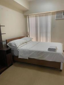 a bedroom with a large bed with a window at Torre De Manila Stunning Apartment in Manila
