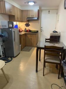 a small kitchen with a table and a refrigerator at Torre De Manila Stunning Apartment in Manila