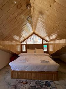 a bedroom with a large bed in a wooden ceiling at The Exotic Retreat in Manāli