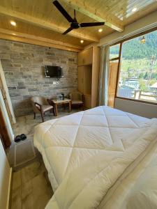 um quarto com uma grande cama branca e uma televisão em The Exotic Retreat em Manali