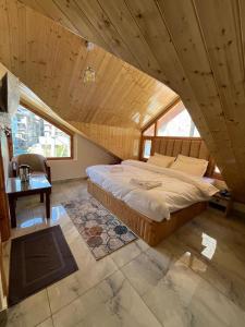 um quarto com uma cama grande num quarto com uma janela em The Exotic Retreat em Manali