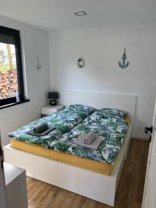 un letto in una piccola camera con copriletto di BananaHouse a Kruszwin