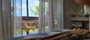 a bedroom with a bed and a large window at Pousada Bambuí Terra Ronca in São João