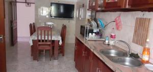 una cucina con lavandino e una cucina con tavolo di 2 chambres d’hôtes a Tarrafal