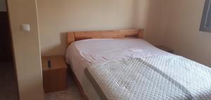 een kleine slaapkamer met een bed met een houten hoofdeinde bij 2 chambres d’hôtes in Tarrafal