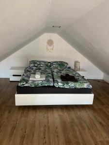 uma cama num quarto branco com piso em BananaHouse em Kruszwin