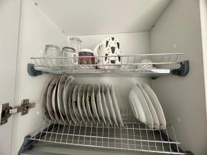 una cocina con platos y utensilios en un estante en Quiet, well located, Riga Apartment, en Riga