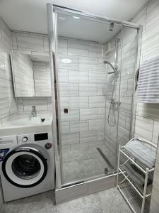 y baño con lavadora y ducha. en Quiet, well located, Riga Apartment, en Riga