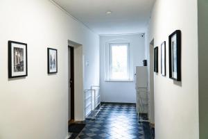 a hallway with white walls and pictures on the walls at J&M Apartments in Ústí nad Labem