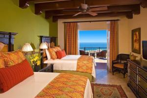 a bedroom with two beds and a balcony with the ocean at Incredible 3BR Ocean View Villa in Cabo San Lucas in Cabo San Lucas