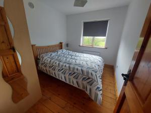 3 bed semi-detached house in a quite estate في Bruff: غرفة نوم صغيرة بها سرير ونافذة