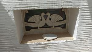 two white birds in a box on a wall at Παραδοσιακό Σπίτι στον Πύργο in Panormos