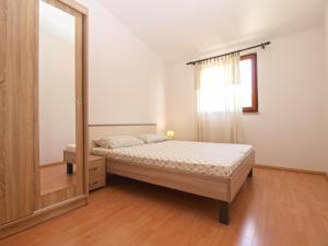 - une chambre avec un lit et un miroir dans l'établissement Ferienwohnung für 4 Personen ca 45 qm in Premantura, Istrien Istrische Riviera, à Premantura