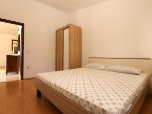 - une chambre avec un grand lit et une tête de lit en bois dans l'établissement Ferienwohnung für 4 Personen ca 45 qm in Premantura, Istrien Istrische Riviera, à Premantura