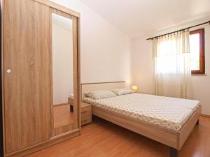 - une chambre avec un lit et un grand miroir dans l'établissement Ferienwohnung für 4 Personen ca 45 qm in Premantura, Istrien Istrische Riviera, à Premantura