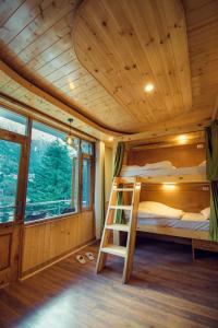 1 dormitorio con litera en una cabaña de madera en The Forest Pinnacle Hostel and Café, Old Manali, en Bashist