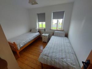 3 bed semi-detached house in a quite estate في Bruff: سريرين في غرفة صغيرة بها نافذتين