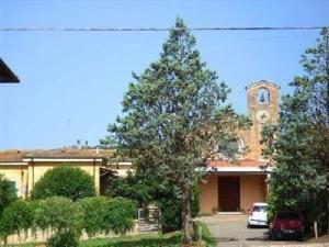een groot gebouw met een boom ervoor bij Ferienwohnung für 5 Personen ca 70 qm in Paganico, Toskana Maremma in Paganico