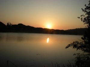 een zonsondergang boven een meer met zonsondergang bij Ferienwohnung für 5 Personen ca 70 qm in Paganico, Toskana Maremma in Paganico