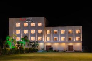 a large building with a sign on it at night at Playotel Resort Bhopal in Bhopal
