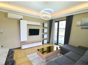 sala de estar con sofá y TV en ACACUS ROYALE en Kigali