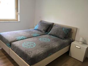 uma cama num pequeno quarto com uma roupa de cama espectrosespectrosspectos em Ferienwohnung für 4 Personen ca 72 qm in Slap ob Idrijci, Küstenland Slowenien em Slap ob Idrijci