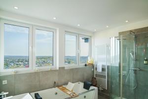 a bathroom with a shower and a sink and windows at Immo-Vision: Penthouse Wellness in Bergneustadt