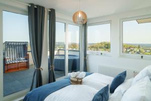 a bedroom with a bed and a large window at Immo-Vision: Penthouse Wellness in Bergneustadt