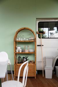 霍尔斯泰因地区诺伊斯塔特Marilyn - Glamping im Mercedes DüDo auf Camping Seeblick的货车旁边的架子上放着盘子