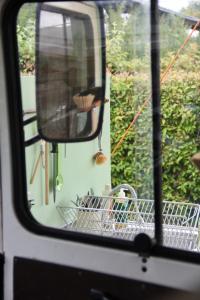 霍尔斯泰因地区诺伊斯塔特Marilyn - Glamping im Mercedes DüDo auf Camping Seeblick的房车后部的碗碟架
