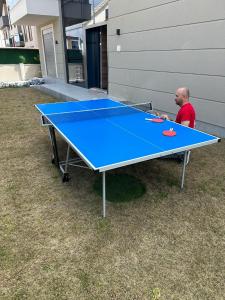 a man sitting at a ping pong table at Living Dream Villa RELAX in Belek