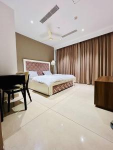a bedroom with a bed and a desk and a piano at Luxury Studios Key8 (2BHK) with Pretty Urbana View in Gurgaon