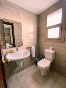 a bathroom with a sink and a toilet and a window at Green Plaza Inn '''Business &Families Only''' in Alexandria