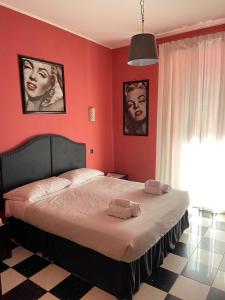 um quarto vermelho com uma cama com duas toalhas em Cardinal Vatican Inn em Roma