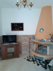 a living room with a fireplace and a piano at Katerina's House in Sitia