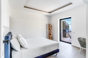 a white bedroom with a bed and a window at Suite San Montano by Feeling Italy in Massa Lubrense