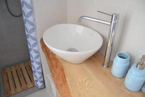 un bagno con lavandino bianco su un bancone in legno di Trullo Scirocco - Apulian House a Locorotondo